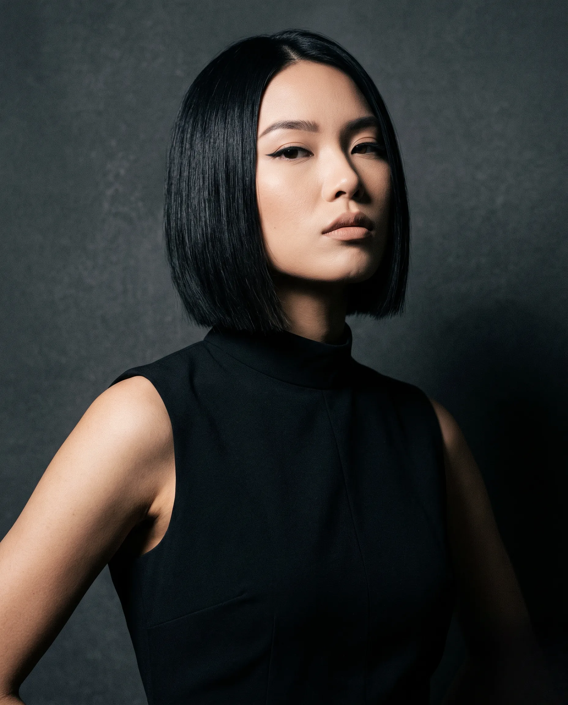 Cliché éditorial de mode mettant en valeur une coupe au carré plongeant symétrique avec un éclairage studio sophistiqué.