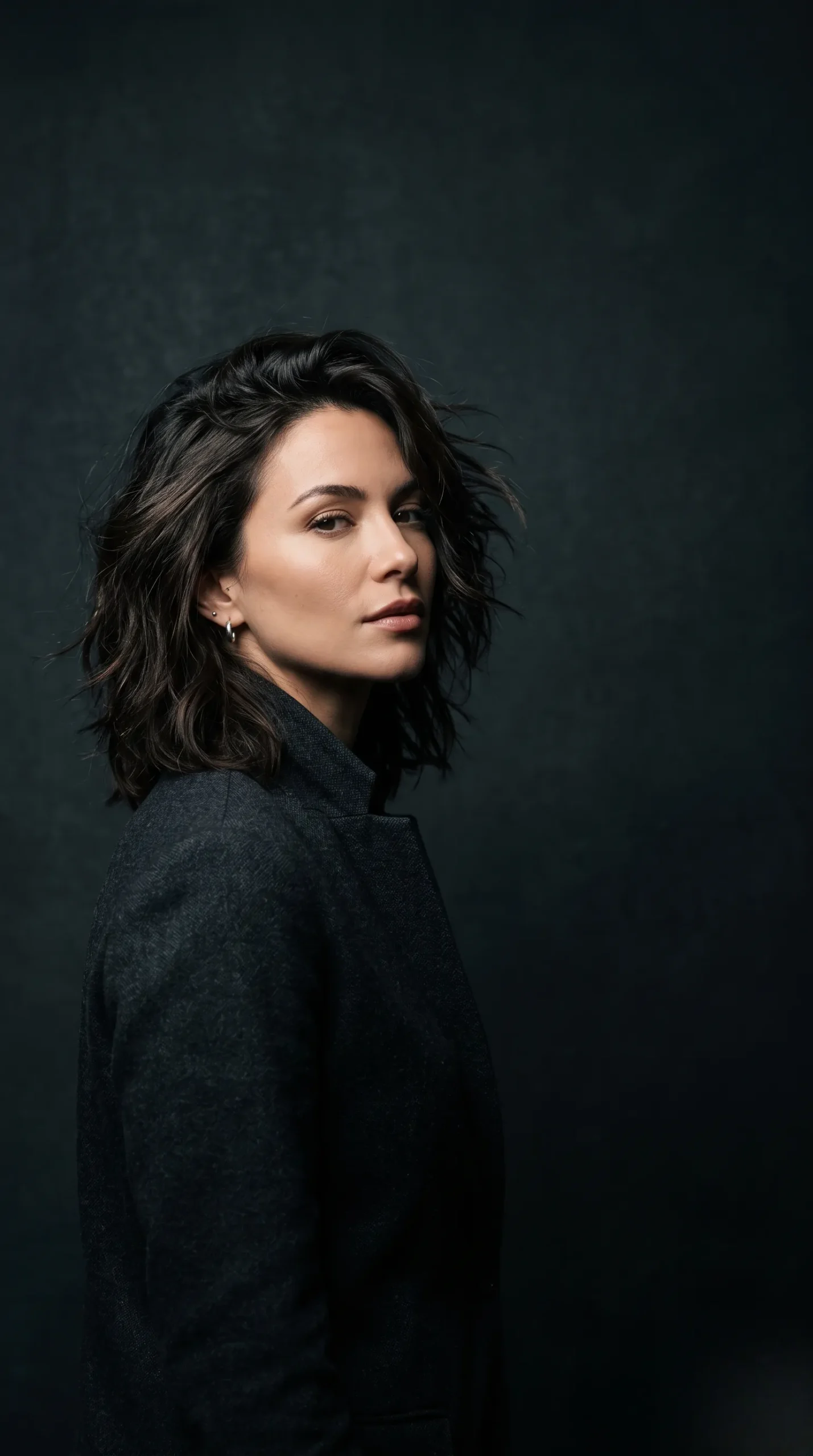 Portrait artistique avec une coupe mi-longue dégradée et un éclairage de studio dramatique.