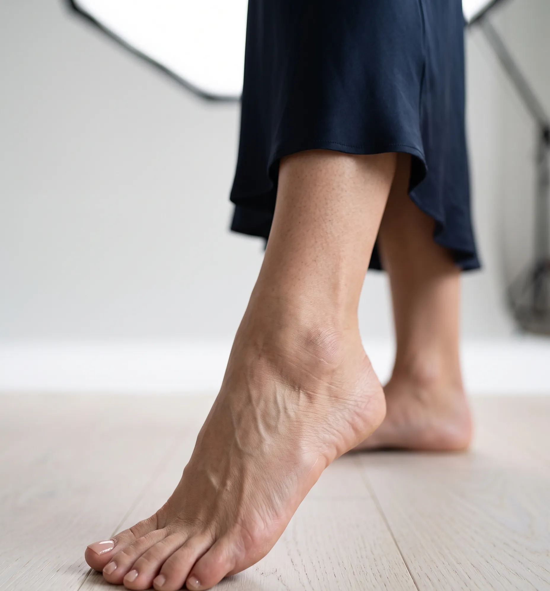 Profil soigné d'un pied de mannequin en studio, évoquant la réalité des défilés et l'importance des soins.