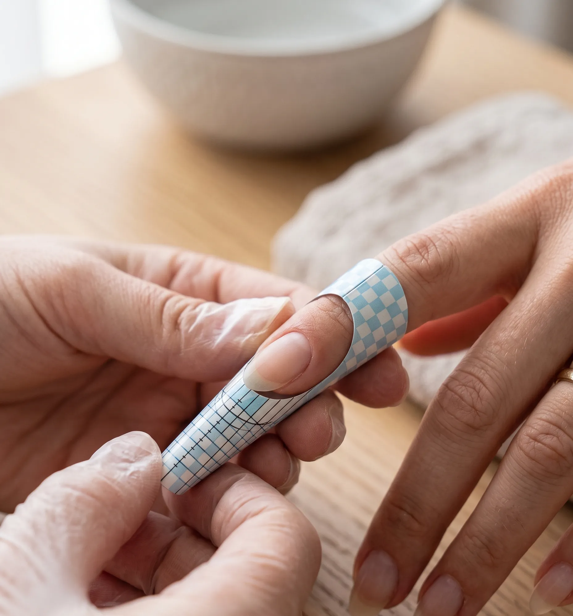 Mise en place minutieuse et ajustement du chablon sous le bord libre de l'ongle.